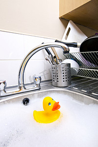 漂浮餐具摄影照片_厨房水槽中的橡皮鸭