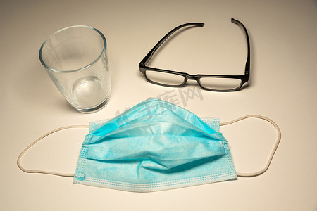外科蓝色面具、玻璃和一个空的玻璃