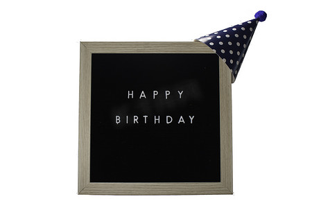 一个写着生日快乐的标志，上面戴着一顶深蓝色的派对帽