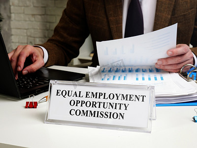 gif佣金摄影照片_一名男子在一张桌子旁工作，平板电脑是平等就业机会委员会 EEOC。