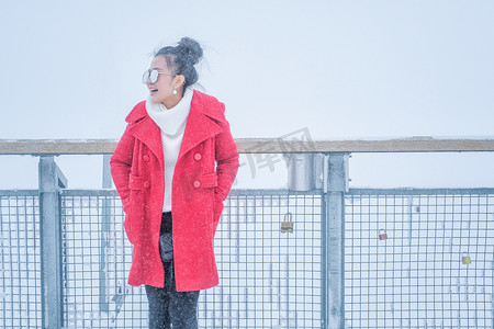 穿着红皮大衣在户外玩雪的漂亮年轻女人