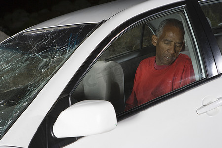 自觉摄影照片_汽车的一位非裔美国人的老人不自觉地坐着
