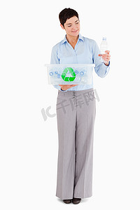 塑料瓶回收箱摄影照片_有塑料瓶和回收箱的妇女