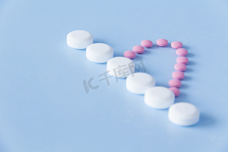 半颗粉红色药物心和蓝色背景上的白色大药丸白色线。