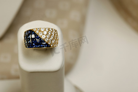 蓝宝石珠宝摄影照片_18k 黄金戒指，镶嵌 5.25 克拉公主方形切割蓝宝石和 1.82 克拉钻石