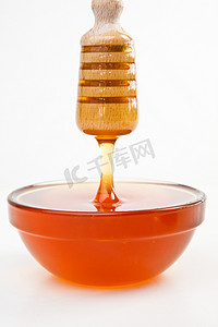 稀薄的蜂蜜滴在满满的蜂蜜碗里