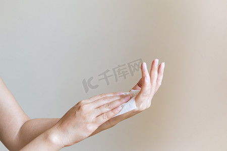 女人用白色软纸巾清洁双手。