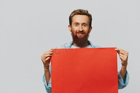 红色文字背景摄影照片_灰色背景中一位成年男性的肖像，上面有一张红色纸，供您设计和文字、布局、复制空间、文字空间