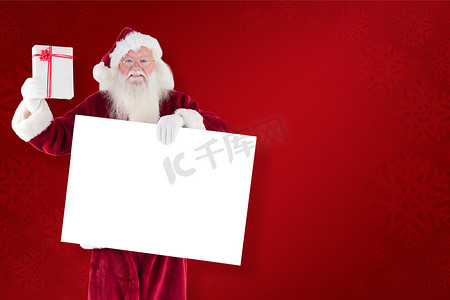 圣诞老人的合成图像在举着牌子的同时展示礼物