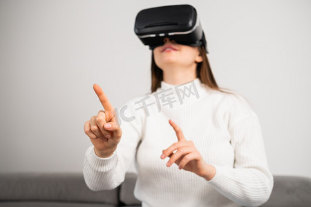 VR 护目镜中的好奇家庭主妇轻扫虚拟界面