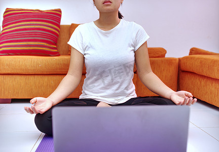 一位年轻女性在她的笔记本电脑上通过在线课程作为模特锻炼