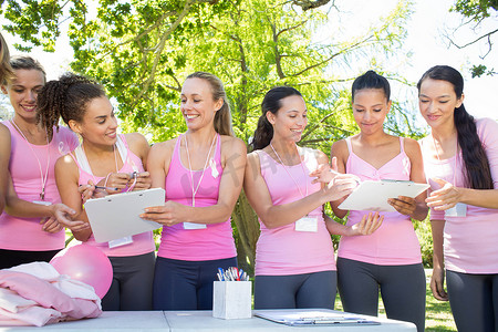 30岁女性摄影照片_微笑的女性组织活动以提高乳腺癌意识