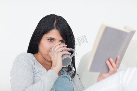 读书时用灰色杯子喝水的女人