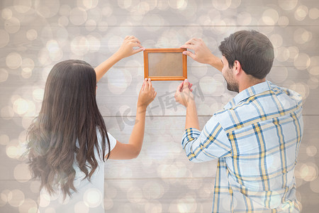 幸福的年轻夫妇张贴相框的合成图像