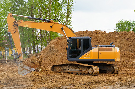 挖坑摄影照片_挖掘机正在为房子挖坑。