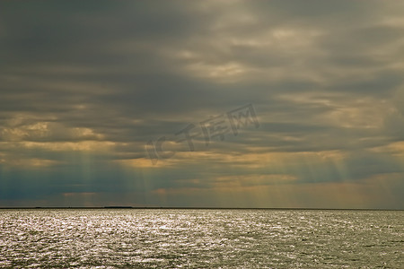 小阳光卡通摄影照片_“阳光穿过北卡罗来纳州俄勒冈湾的云层”