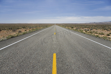 纵向减速标线摄影照片_穿过沙漠的路