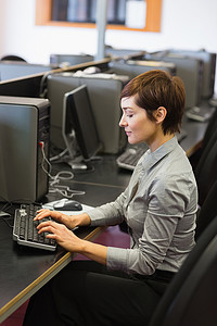 集中精力坐在电脑前打字的女人
