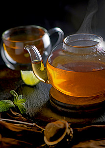 茶的概念，木背景中茶壶，茶道，透明杯中的绿茶