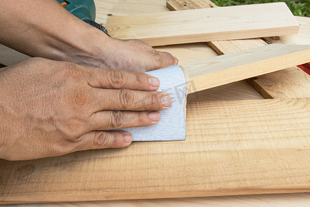工人手工抛光砂纸木材。