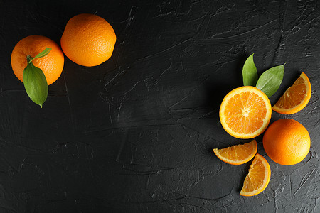 平躺组合物，带有成熟的橙子和黑色背景、顶视图上的文字空间