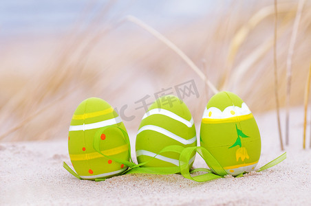沙滩装饰摄影照片_复活节彩蛋在沙滩上
