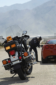 摩托车在路上，背景是警察开车