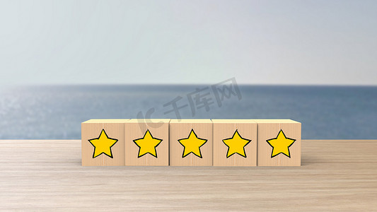 木制卡通立方体五黄星评论模糊海与天空背景。