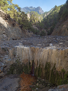 水流干涸摄影照片_Cascada de Colores 小瀑布位于 Caldera de Taburiente 的火山口，几乎是干涸的瀑布，水流因矿泉水而色彩缤纷。