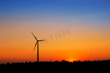 在日落天空的风力发电机风车