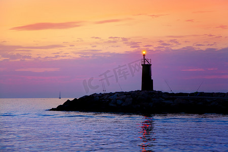 发光在蓝色紫色海的日出灯塔