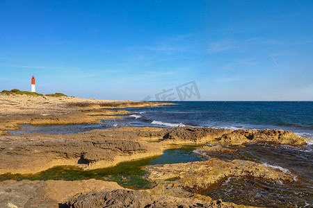 海滨灯塔风景摄影照片_与灯塔的岩石海滨风景