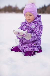 快乐的小女孩在冬天阳光明媚的日子里在雪地上玩得开心