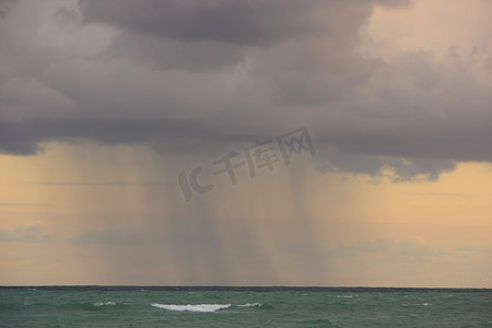 暴雨摄影照片_日出时海上暴雨