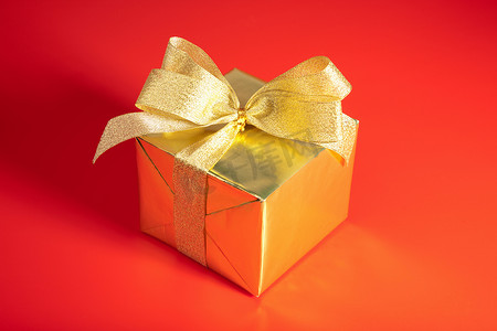 红色背景上带蝴蝶结的金色礼盒