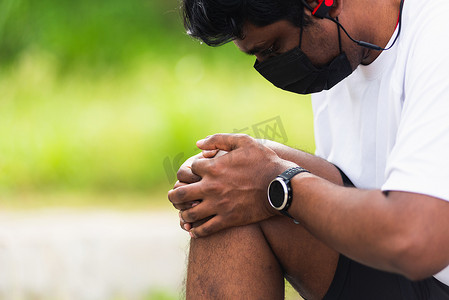 运动赛跑者黑人男子戴手表坐着双手关节抱膝