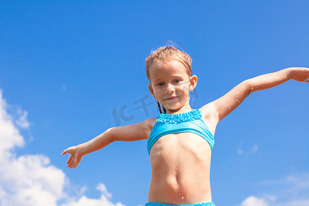 可爱的小女孩张开双臂的蓝天背景