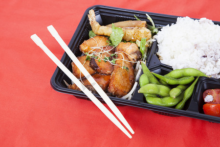 红色背景中用筷子放在托盘中的健康食品