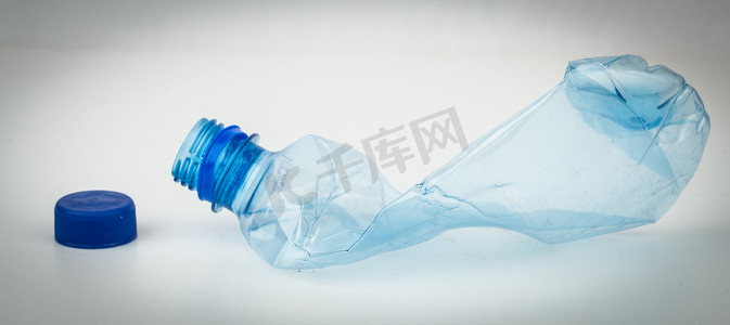 压碎的空塑料瓶和蓝色盖帽