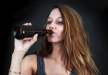 喝啤酒摄影照片_醉酒的女人在黑人身上喝啤酒