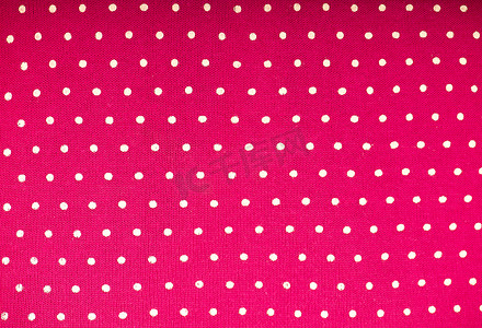 浅粉色背景上的波尔卡圆点的粉色圆点织物。