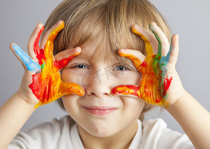 玩颜料的孩子摄影照片_手涂上五颜六色的颜料