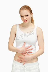 腹诊摄影照片_痛苦的女人把手放在肚子上