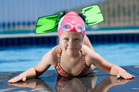 游泳帽、 眼镜、 鳍在游泳池附近的小孩