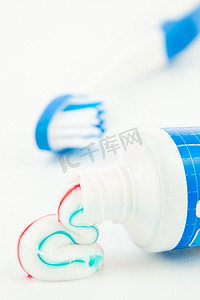在牙刷旁边的蓝色牙膏管