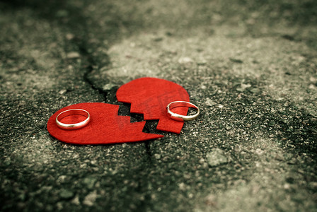 离婚概念 — 破碎的心与破裂的沥青上的结婚戒指