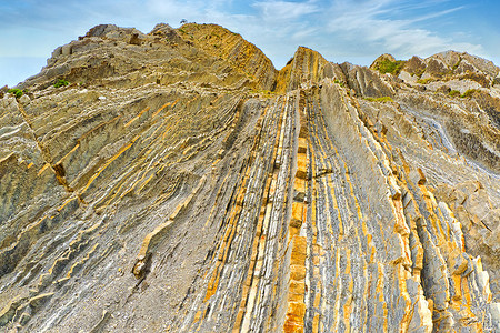 地理地质摄影照片_陡峭倾斜的 Flysch 层，西班牙巴斯克海岸联合国教科文组织世界地质公园
