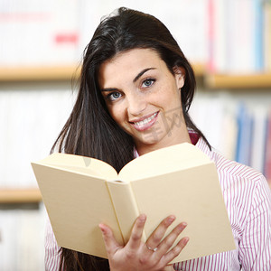 手拿书在书店微笑的女学生 — 模特