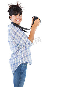 微笑着用相机拍照的年轻女子
