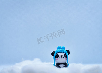 黑色背景中孤立的冬雪中的小熊猫瓷俑